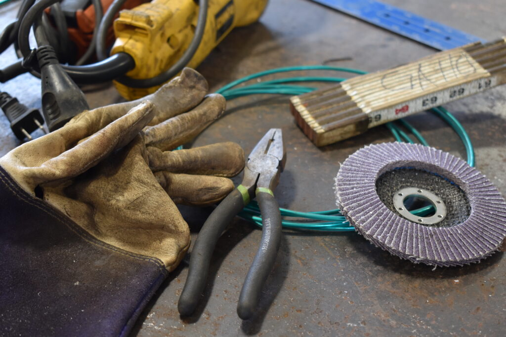 Tools of the trade. Welding glove, grinding wheel, rule and pliers